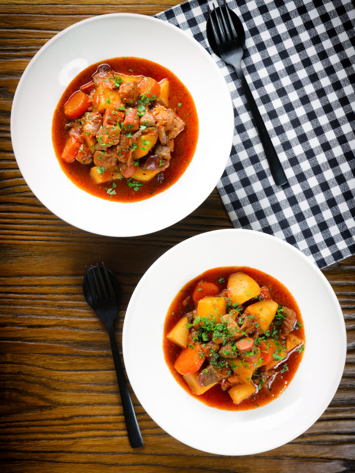 Overhead Filipino pork menudo with liver, hotdog sausages, potatoes and carrots.