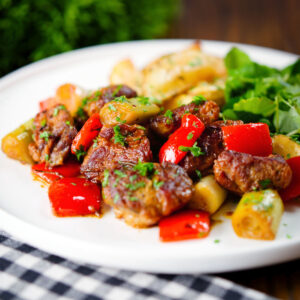 Greek pork tigania with peppers and leeks, served with watercress and lemon potato wedges.