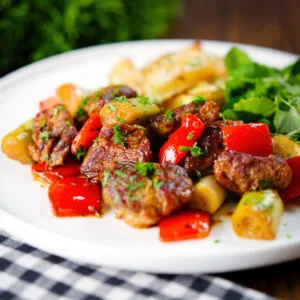 Greek pork tigania with peppers and leeks, served with watercress and lemon potato wedges.