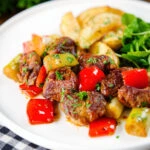 Greek pork tigania with peppers and leeks, served with watercress and potato wedges.