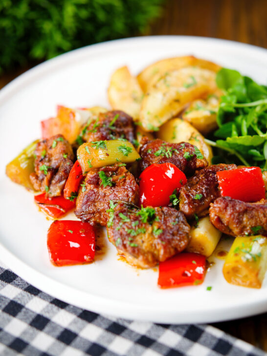 Greek pork tigania with peppers and leeks, served with watercress and potato wedges.