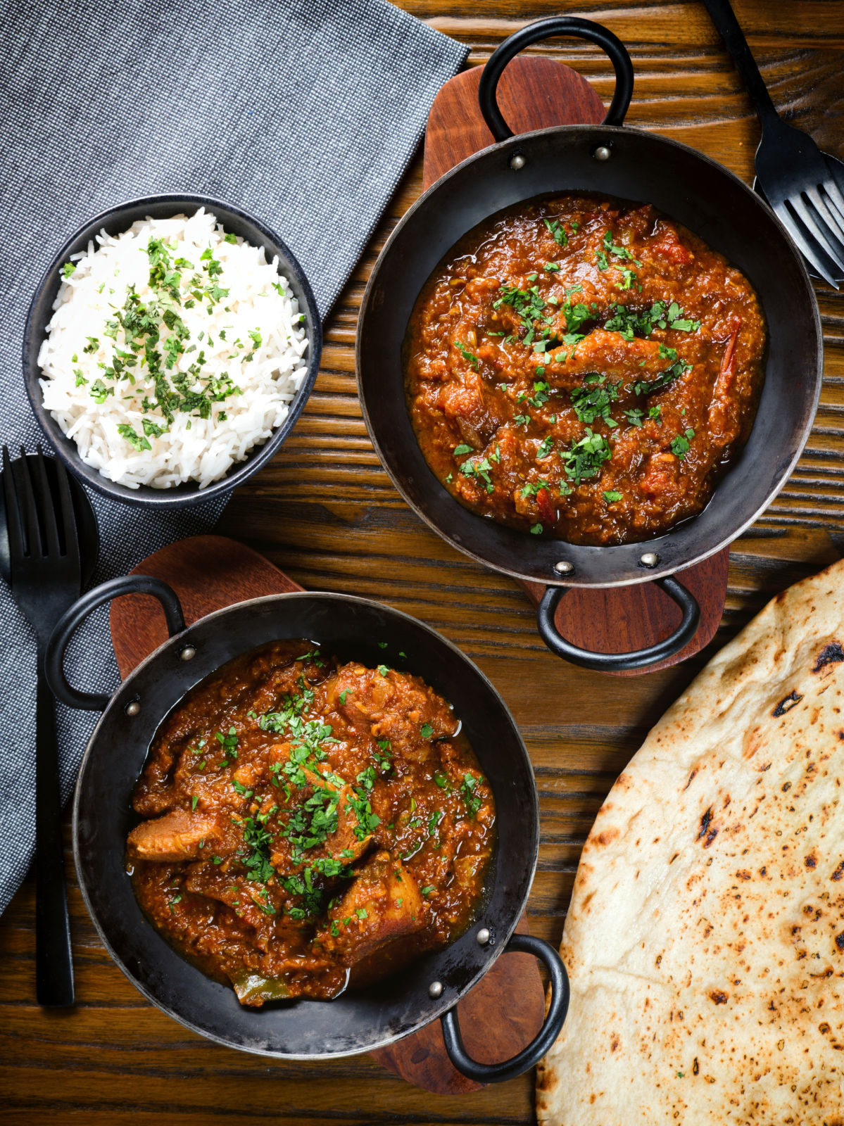 Overhead Indian (Goan) inspired pork vindaloo curry served with rice and naan bread.