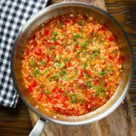 Overhead Portuguese arroz con tomate (tomato rice) side dish in its cooking pan.