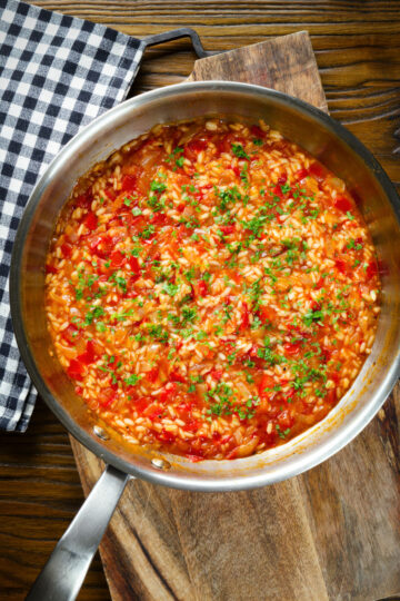 Overhead Portuguese arroz con tomate (tomato rice) side dish in its cooking pan.