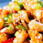 Close-up spicy squid stir fry in oyster sauce and crispy chilli oil served with white rice.