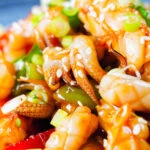 Close-up spicy squid stir fry in oyster sauce and crispy chilli oil served with white rice.