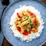 Overhead spicy squid stir fry in oyster sauce and crispy chilli oil served with white rice.