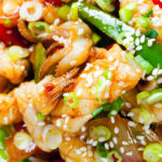 Overhead close-up spicy squid stir fry in oyster sauce and crispy chilli oil served with white rice.