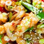 Overhead close-up spicy squid stir fry in oyster sauce and crispy chilli oil served with white rice.