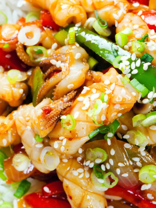 Overhead close-up spicy squid stir fry in oyster sauce and crispy chilli oil served with white rice.