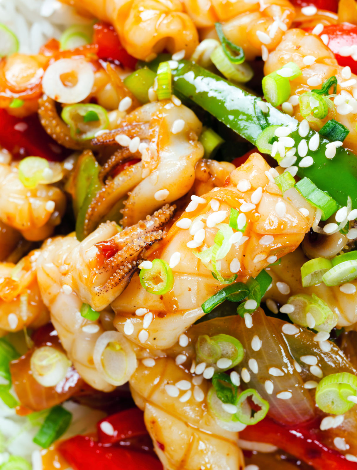 Overhead close-up spicy squid stir fry in oyster sauce and crispy chilli oil served with white rice.