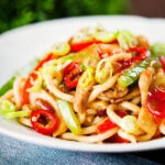 Spicy stir fried sweet chilli chicken udon noodles with peppers.