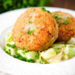Tinned salmon and sardine fish cakes served with creamed leeks.
