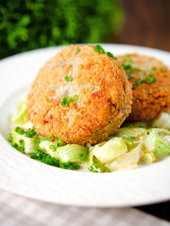 Tinned salmon and sardine fish cakes served with creamed leeks.