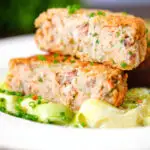 Tinned tinned salmon and sardine fish cake cut open to show filling and texture.