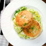Overhead tinned salmon and sardine fish cakes served with creamed leeks.
