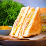 Crispy golden air fryer cooked ham and cheese toastie with piccalilli.