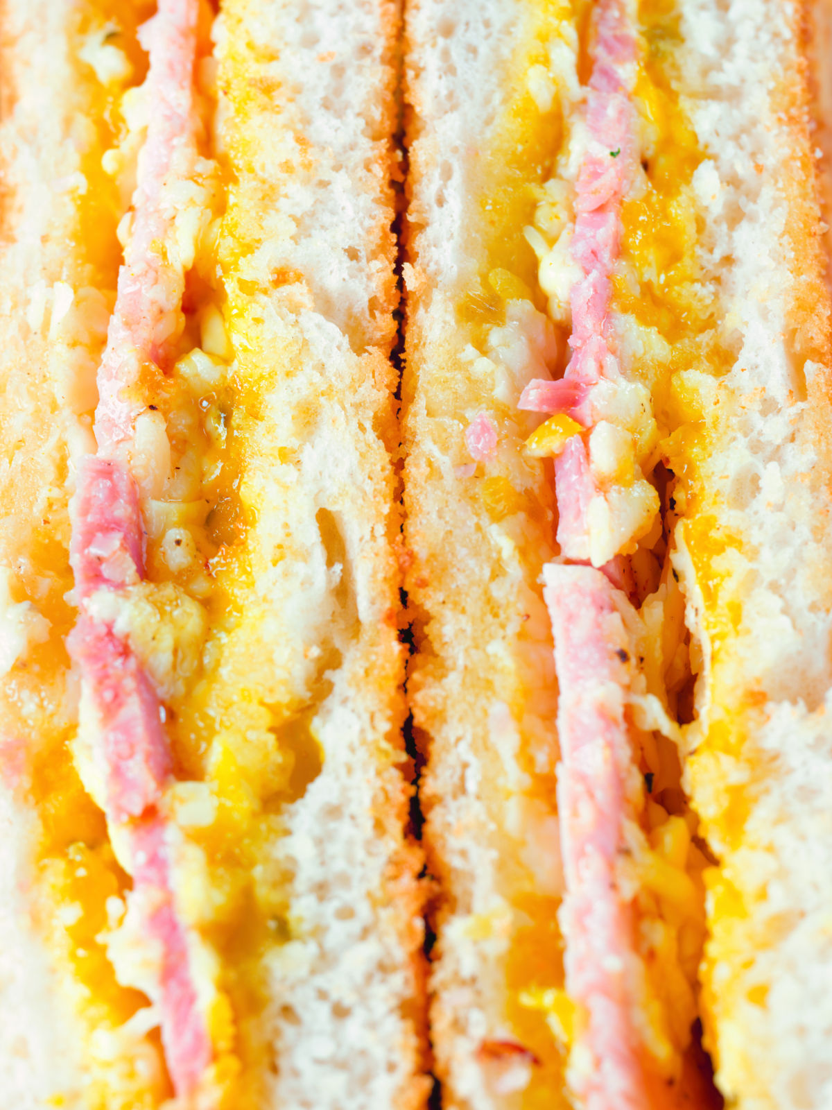 Close-up crispy air fryer cooked ham and cheese toastie with piccalilli.