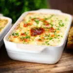 Individual cheesy baked bean pasta bakes (bean mac and cheese) with snipped chives.