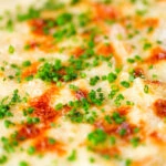 Close-up individual cheesy baked bean pasta bakes (bean mac and cheese).