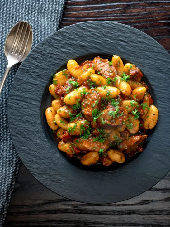 Overhead sausage gnocchi in a rich tomato sauce served.