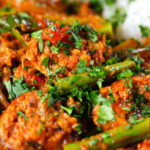 Close-up Indian beef & pork sausage curry with green beans served with plain rice.