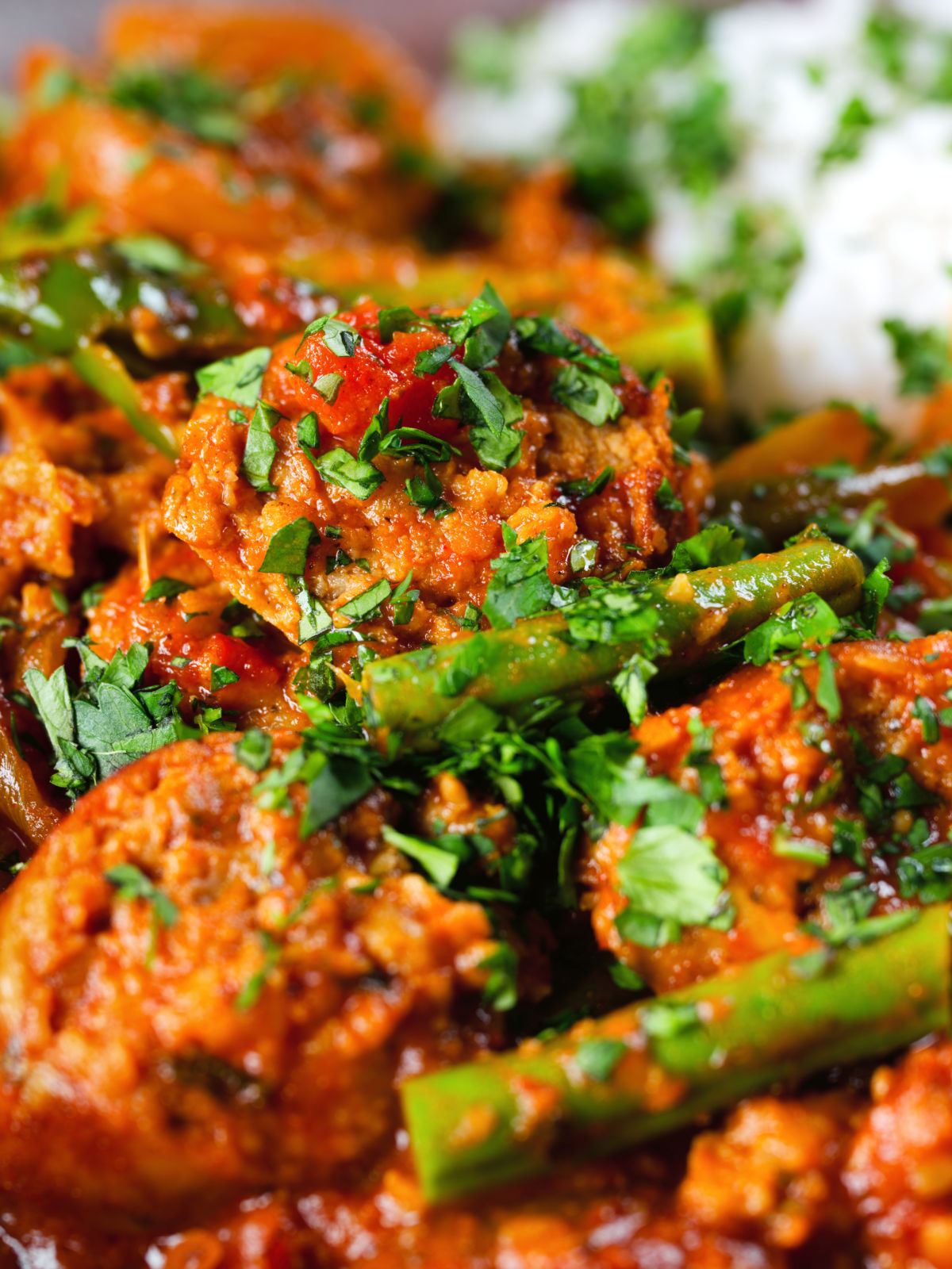 Close-up Indian beef & pork sausage curry with green beans served with plain rice.