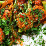 Close-up overhead Indian beef & pork sausage curry with green beans served with plain rice.
