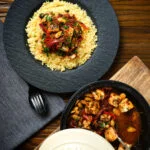 Overhead harissa halloumi tagine with almonds served with buttered couscous.