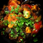 Overhead close-up Indian-influenced chicken, mushroom and tomato curry served in a karai.