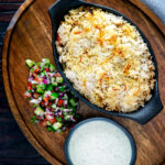 Baked vegan mushroom biryani served with mint raita and kachumber salad.