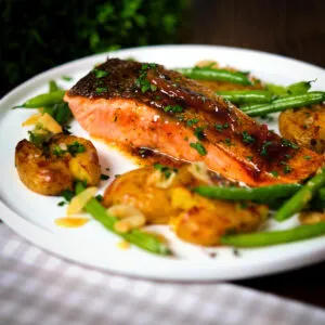 Orange and marmalade glazed salmon fillet with crushed new potatoes and green beans amandine