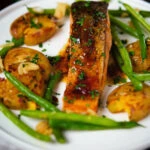 Orange and marmalade glazed salmon with roasted new potatoes and green beans.