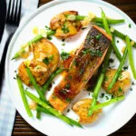 Overhead orange and marmalade glazed salmon with new potatoes and green beans.
