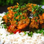 Close-up Andhra style chicken curry (kodi kura) served with basmati rice.
