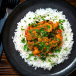 Overhead Andhra style chicken curry (kodi kura) served with basmati rice.