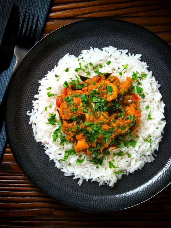 Overhead Andhra style chicken curry (kodi kura) served with basmati rice.