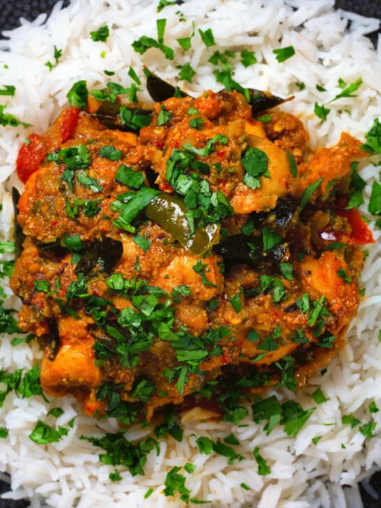 Overhead close-up Andhra style chicken curry (kodi kura) served with basmati rice.