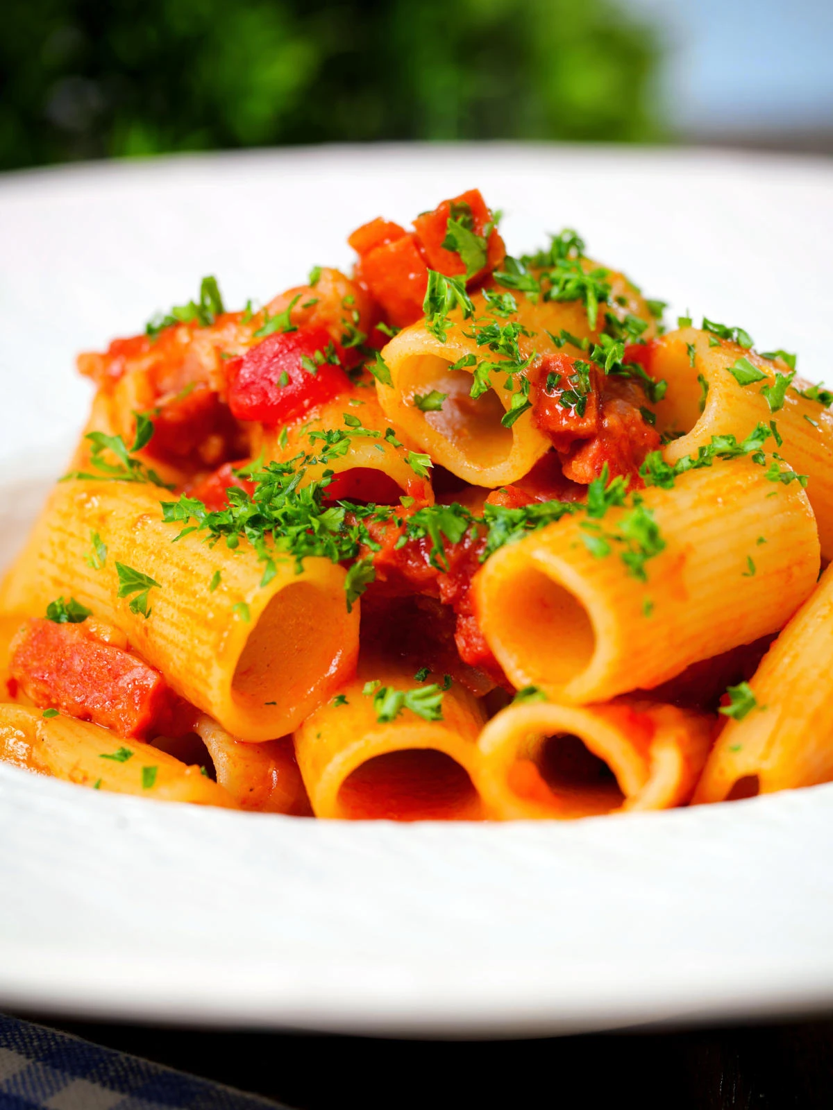 Close-up chorizo sausage and bacon pasta in a tomato sauce.