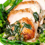 Close-up creamy chicken and oyster mushroom Florentine served with green vegetables.