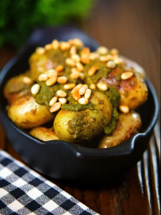 Brown butter and basil pesto potatoes garnished with pine nuts.