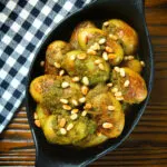 Overhead brown butter and basil pesto potatoes garnished with pine nuts.