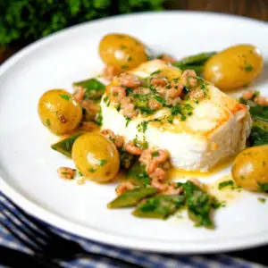 Roasted halibut steak with a potted shrimp and vermouth sauce, served with new potatoes and runner beans