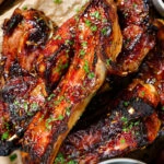 Close-up overhead sticky BBQ sauce glazed lamb spare ribs served with pickles.