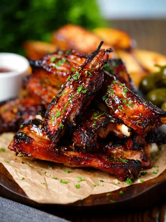 Sticky BBQ sauce glazed lamb spare ribs served with potato wedges and pickles.