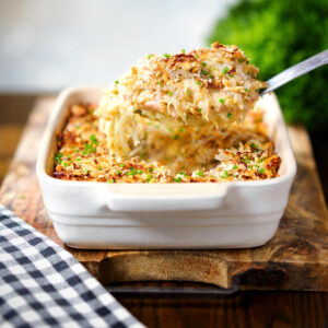 Baked cheesy chicken and bacon gratin with snipped chives.