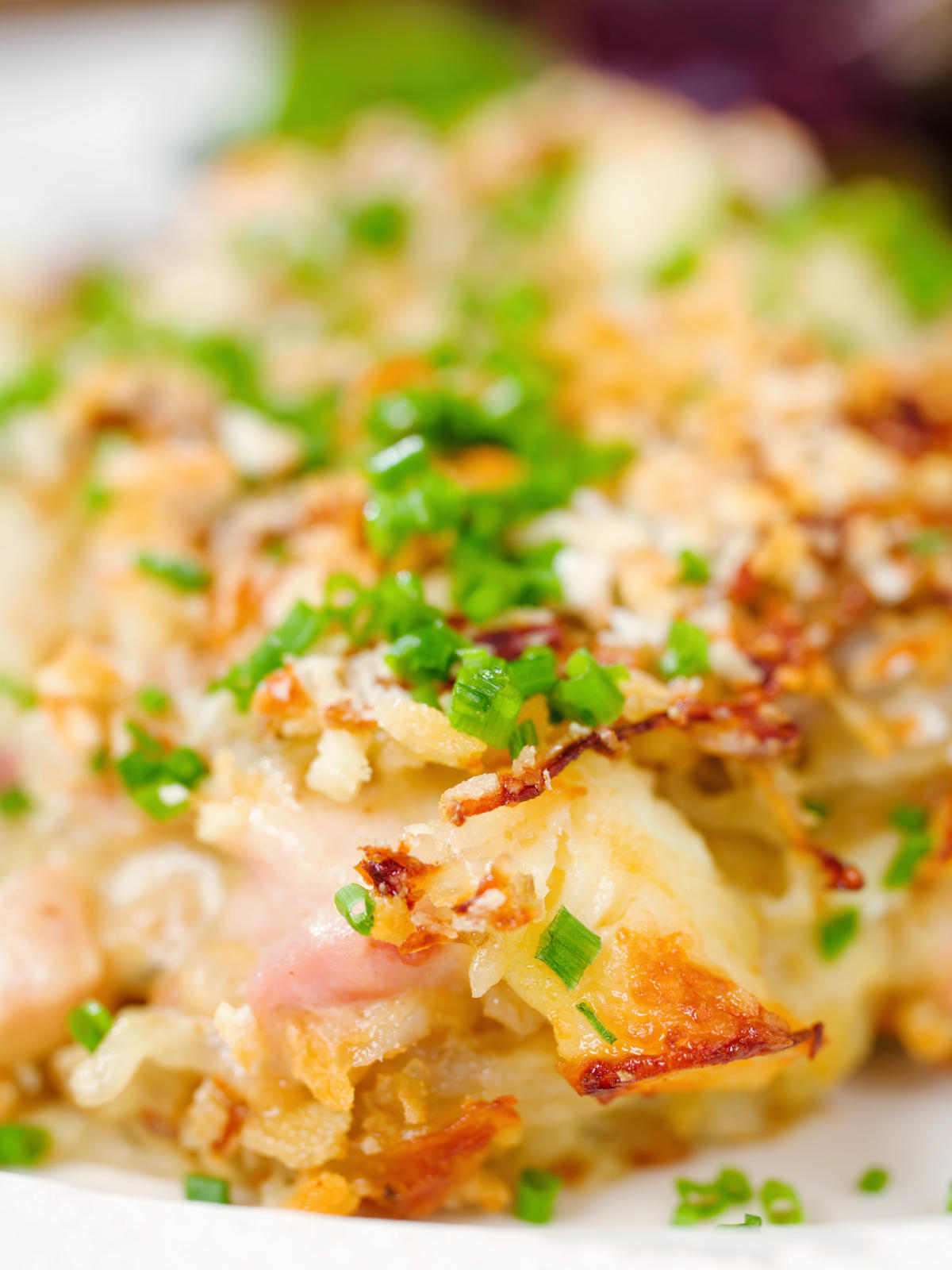 Close-up cheesy chicken, bacon and potato gratin.