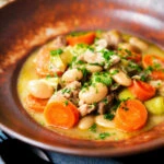Chicken and butterbean stew with leeks and carrots served with bread.
