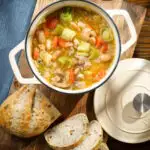 Overhead chicken and butterbean stew with leeks and carrots served in a cooking pot.