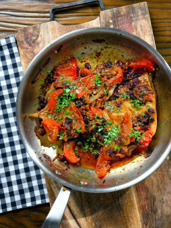 Overhead curried pork chops with tomatoes, onions and raisins.